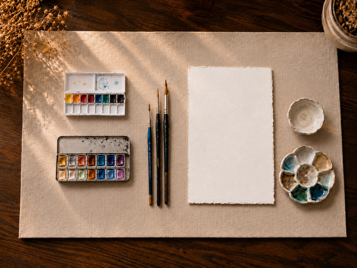 Flat-lay of the recommended watercolour paints, brushes and paper